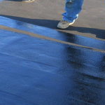 Roofer applying waterproofing product